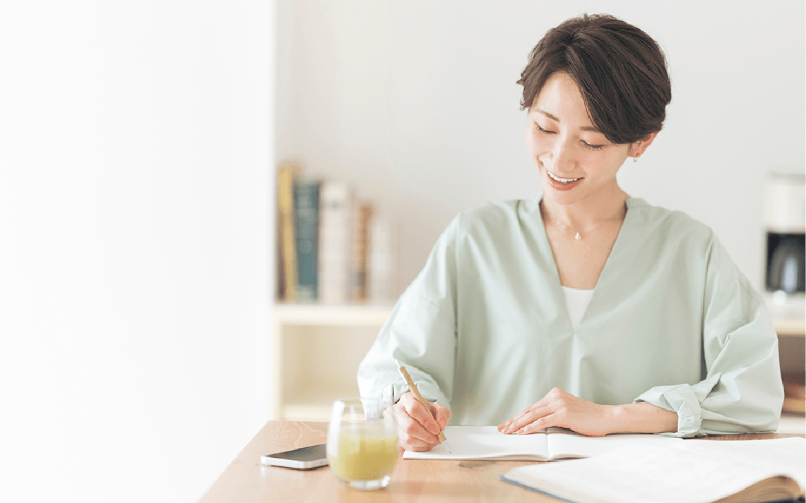 ノートに書き込む女性の写真
